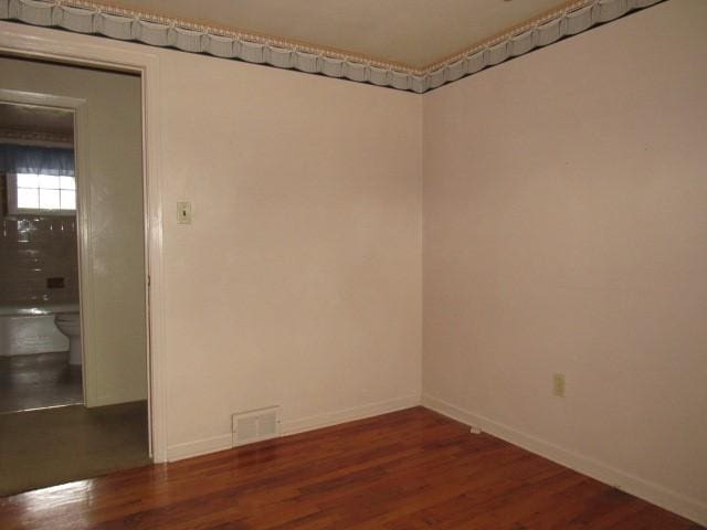 empty room with dark hardwood / wood-style flooring