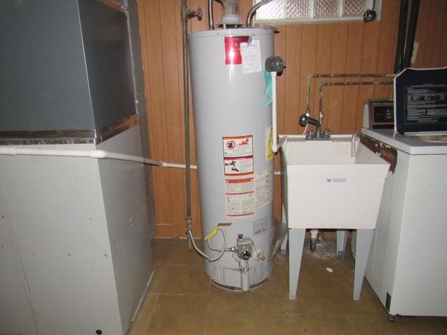 utilities featuring heating unit, sink, washer / clothes dryer, and water heater