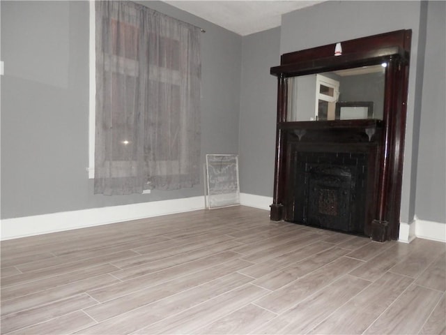 unfurnished living room with a fireplace and light wood-type flooring