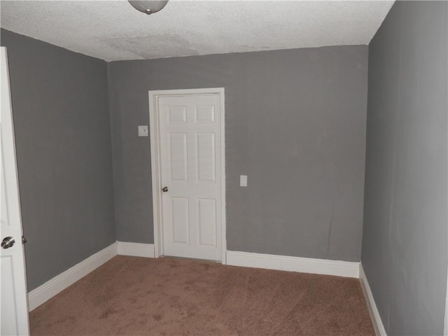 empty room featuring carpet floors and a textured ceiling