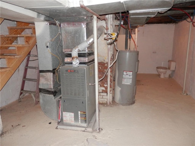 utility room featuring heating unit and electric water heater