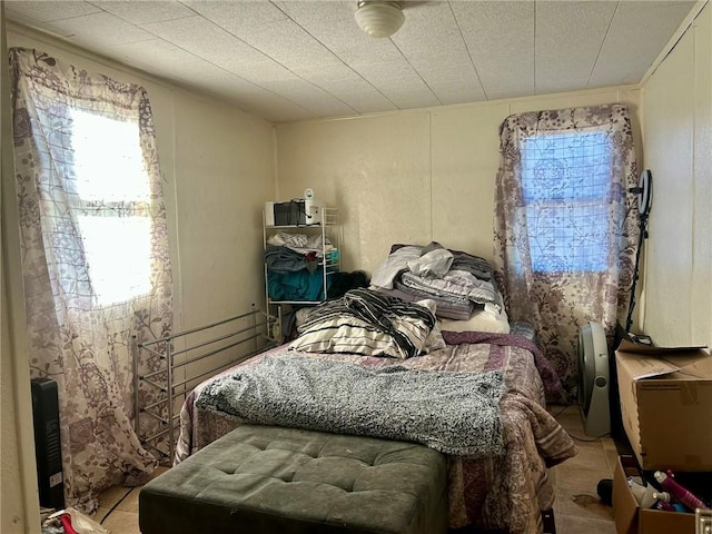 bedroom with multiple windows and light tile patterned flooring