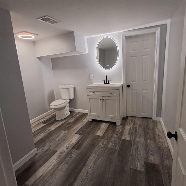 bathroom featuring toilet, vanity, and hardwood / wood-style flooring