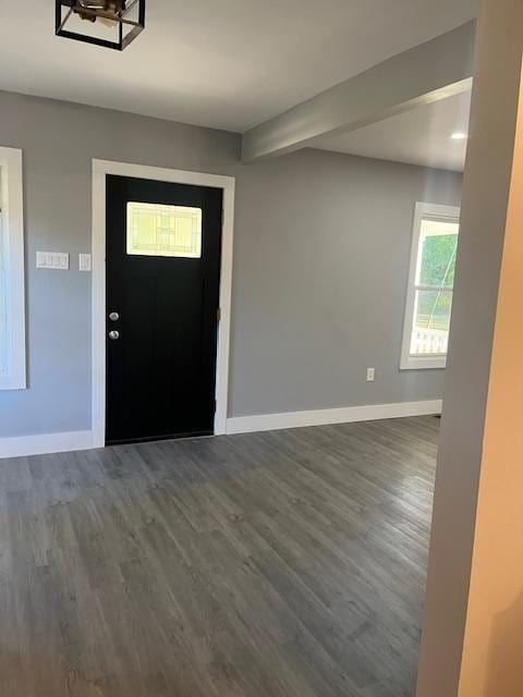 entryway with dark hardwood / wood-style flooring and a notable chandelier