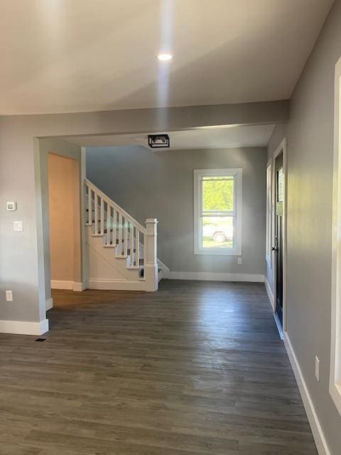 unfurnished living room with dark wood-type flooring