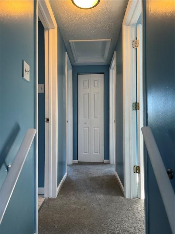 corridor with carpet and a textured ceiling