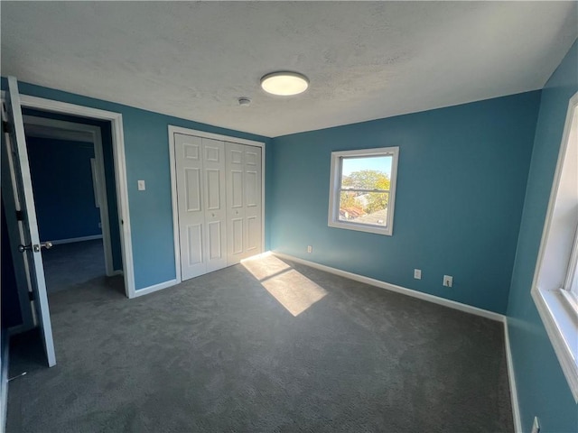 unfurnished bedroom with a closet and dark carpet