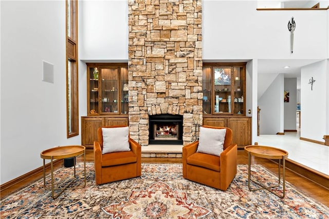 living area featuring hardwood / wood-style flooring and a stone fireplace