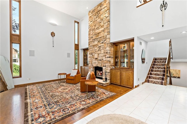 living room featuring a fireplace, hardwood / wood-style floors, and a high ceiling