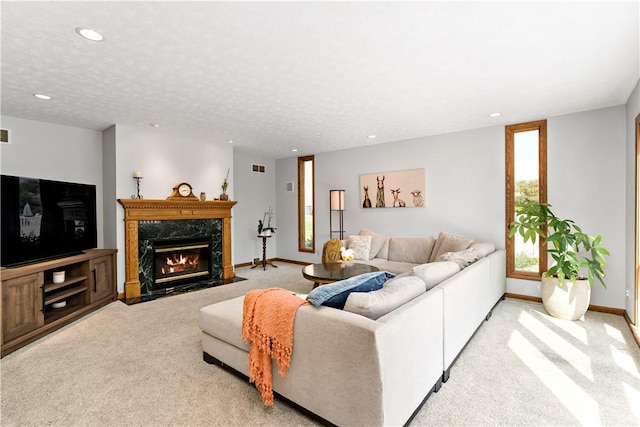 carpeted living room with a textured ceiling and a fireplace