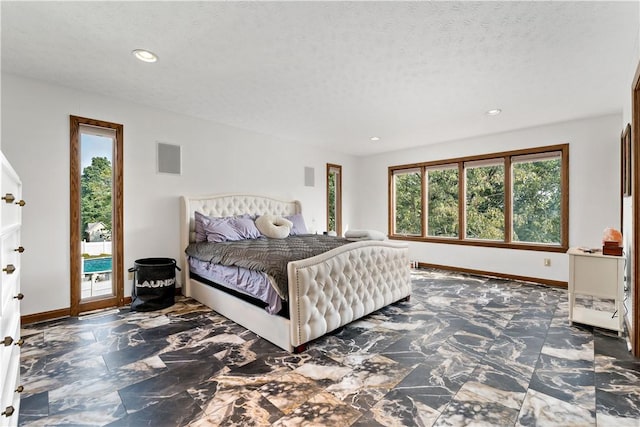 bedroom with access to exterior and a textured ceiling