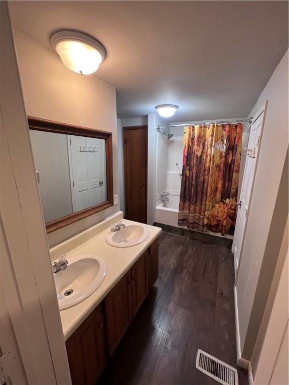 bathroom featuring wood-type flooring, vanity, and shower / bath combo with shower curtain