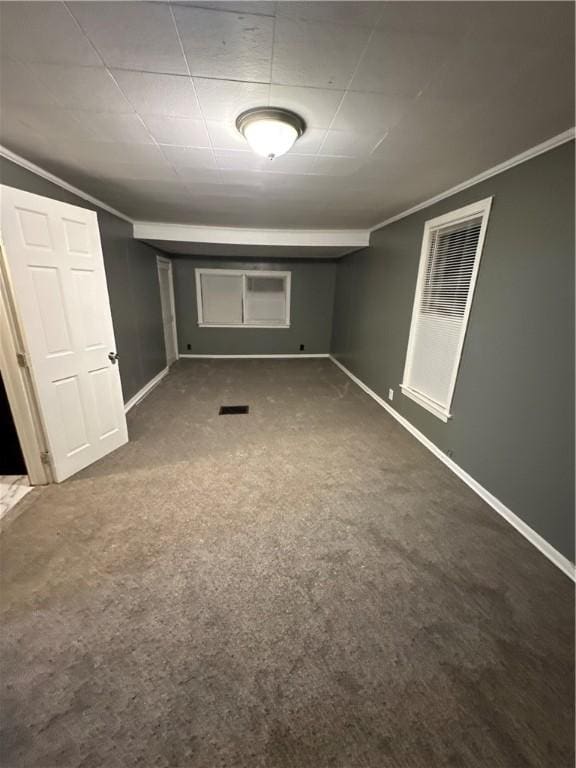 basement featuring dark carpet and ornamental molding