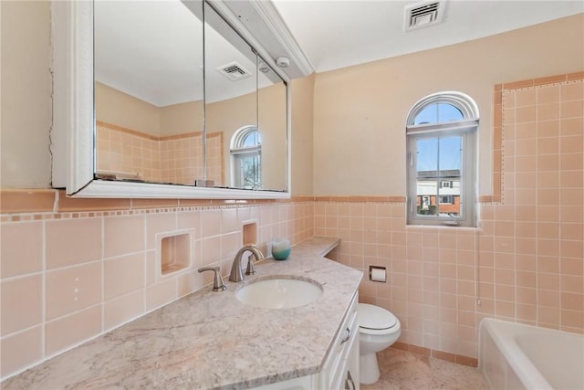 bathroom with vanity, tile walls, and toilet