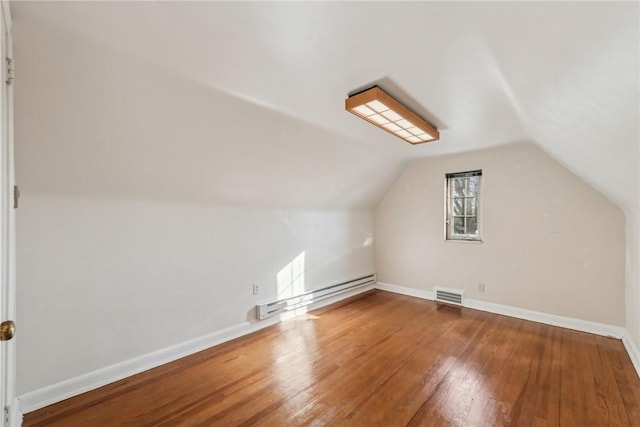 additional living space featuring wood-type flooring and vaulted ceiling