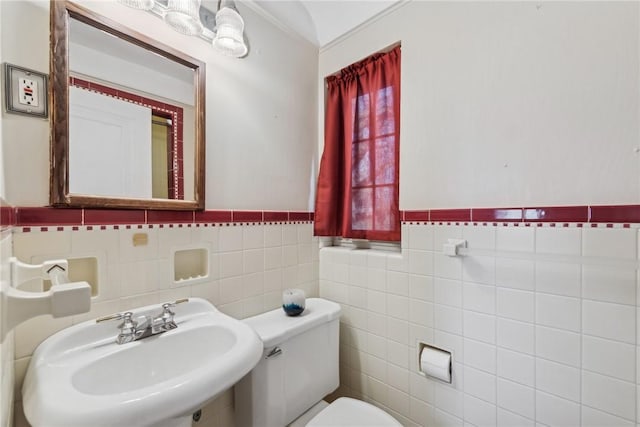 bathroom featuring sink, tile walls, and toilet