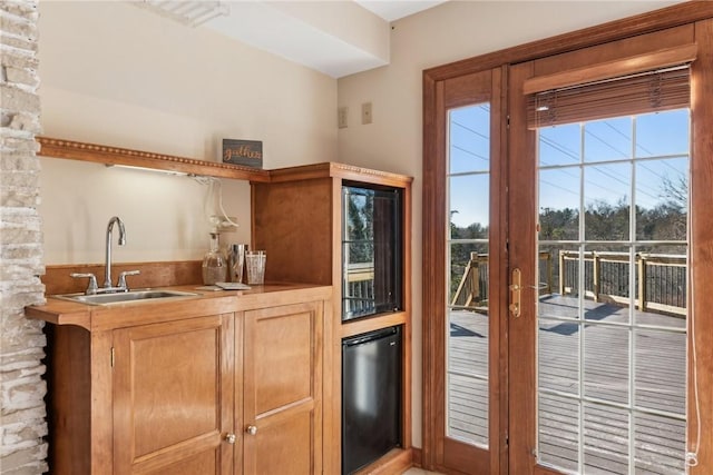 kitchen featuring black refrigerator, sink, and wine cooler