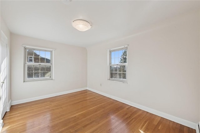 spare room with plenty of natural light and light hardwood / wood-style floors