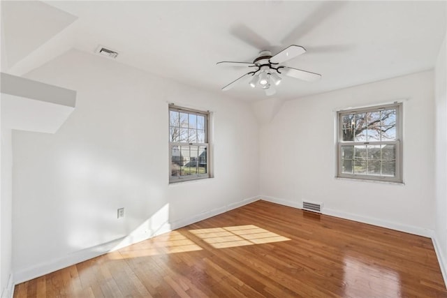 empty room with hardwood / wood-style flooring, a wealth of natural light, and ceiling fan