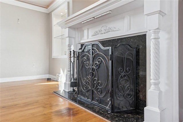 interior details with hardwood / wood-style floors, a premium fireplace, and ornamental molding