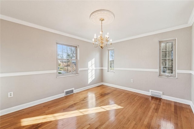 unfurnished room featuring hardwood / wood-style floors, a notable chandelier, and ornamental molding