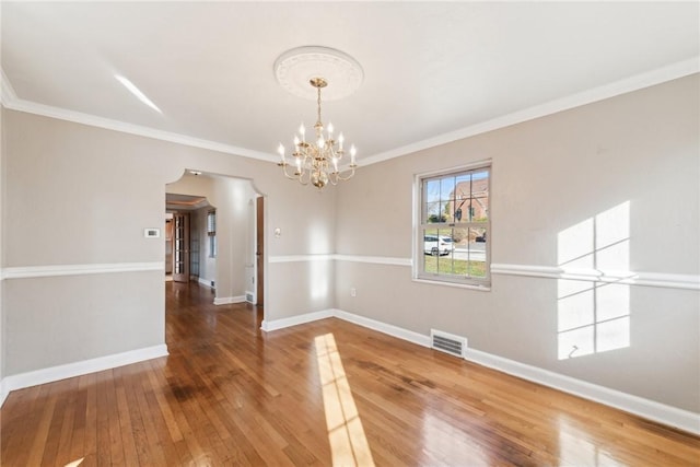 unfurnished dining area featuring hardwood / wood-style floors, a notable chandelier, and crown molding