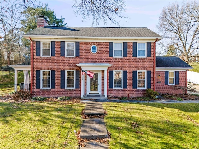 colonial house featuring a front lawn