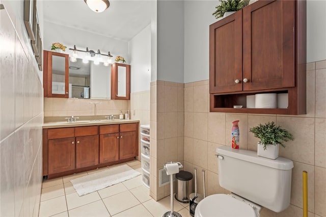 bathroom featuring tile patterned flooring, vanity, tile walls, and toilet