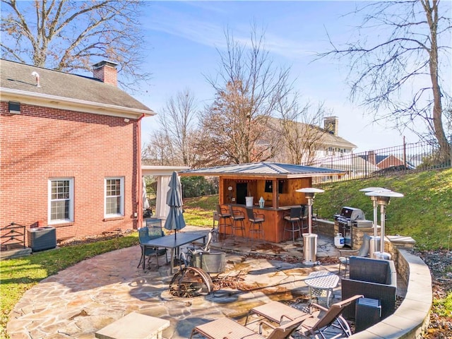 view of patio / terrace with exterior bar and a grill