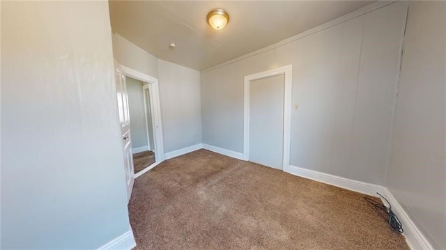 carpeted empty room featuring crown molding