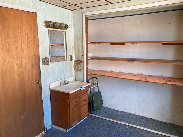 bathroom with vanity and tile walls