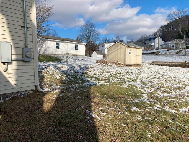 yard covered in snow featuring a storage unit