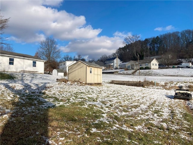 yard covered in snow featuring a storage unit