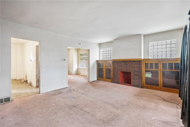 unfurnished living room featuring carpet and a fireplace