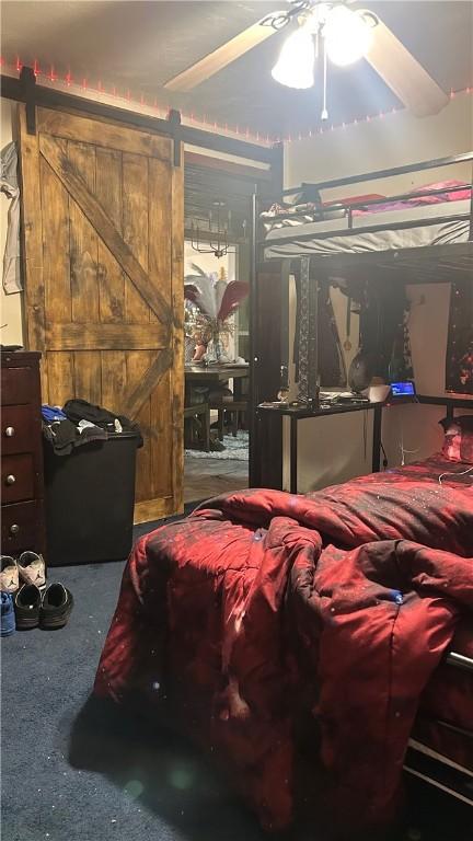 bedroom featuring a barn door and ceiling fan