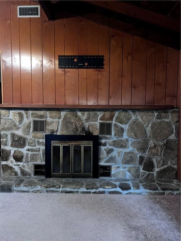 details featuring carpet, a stone fireplace, and wood walls