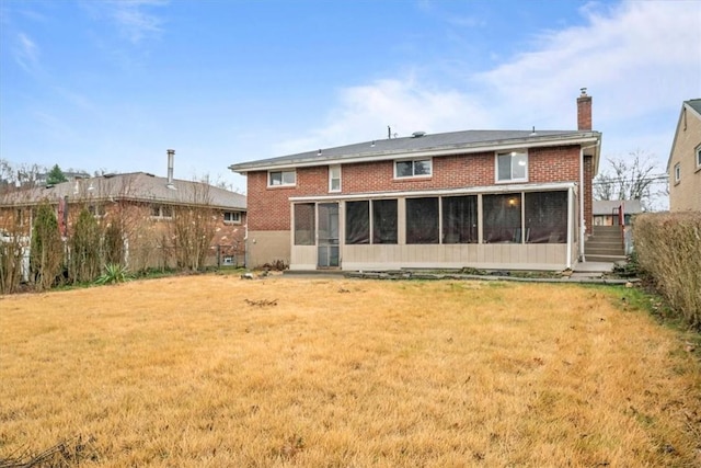 rear view of property with a sunroom and a lawn