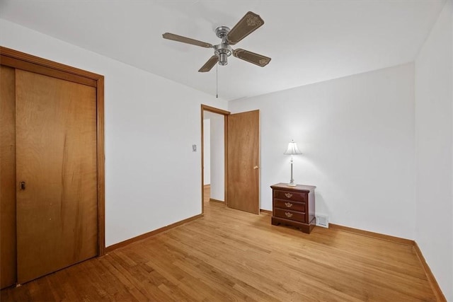 unfurnished bedroom with ceiling fan, a closet, and light wood-type flooring