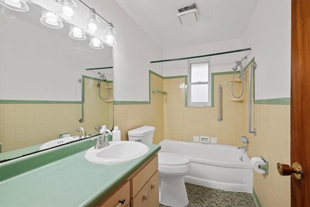 full bathroom featuring tile patterned floors, vanity, tile walls, toilet, and tiled shower / bath