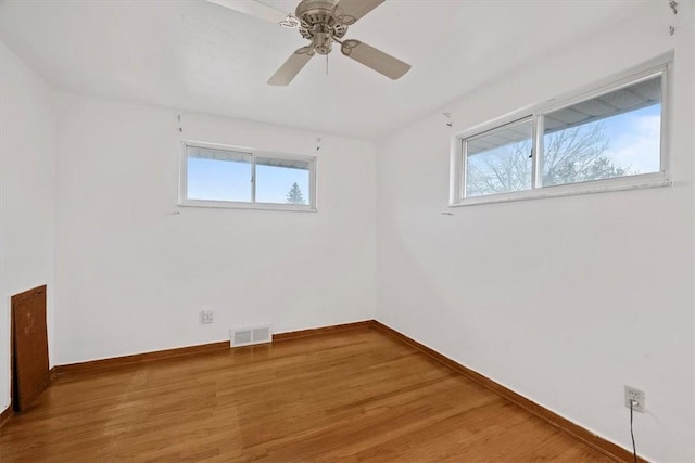 empty room featuring hardwood / wood-style floors, plenty of natural light, and ceiling fan