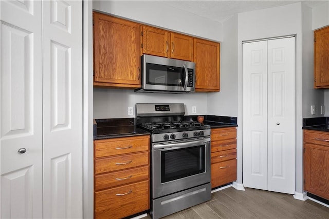 kitchen with dark hardwood / wood-style flooring and appliances with stainless steel finishes