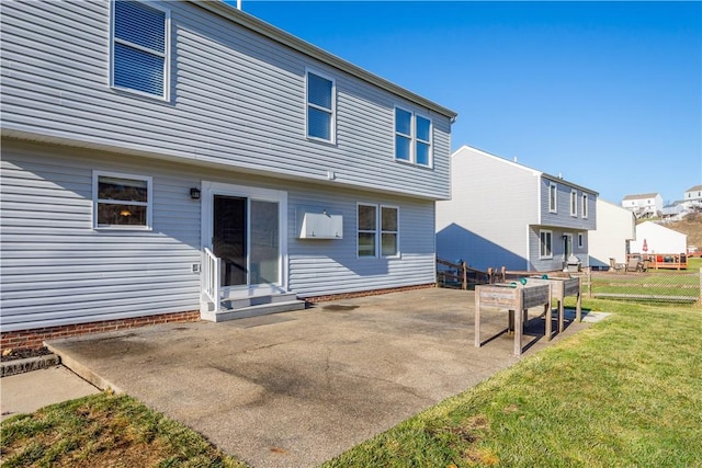 rear view of property featuring a lawn and a patio area