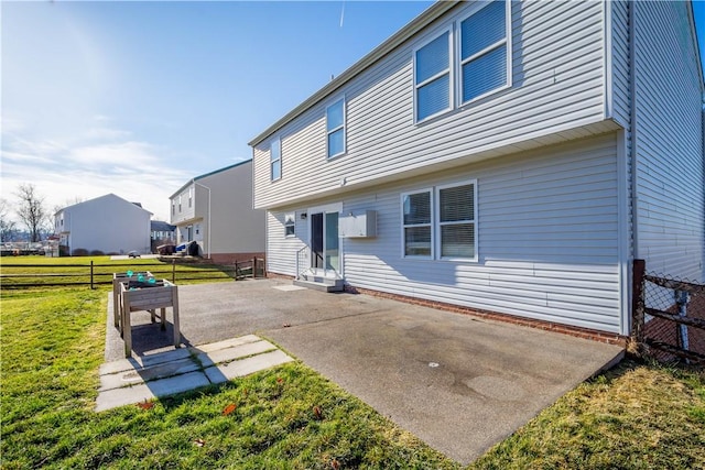 back of property with a lawn and a patio