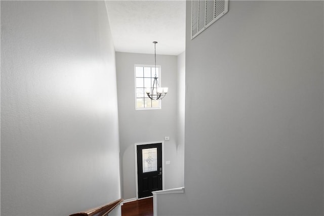 entryway featuring hardwood / wood-style flooring and a chandelier