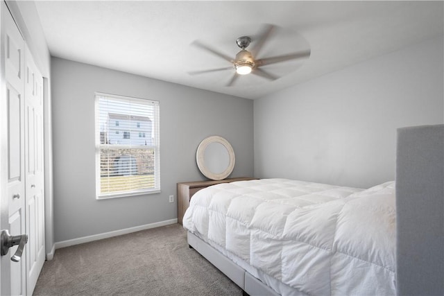 bedroom with ceiling fan, a closet, and light colored carpet