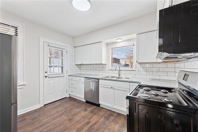 kitchen with appliances with stainless steel finishes, dark hardwood / wood-style flooring, backsplash, sink, and white cabinets