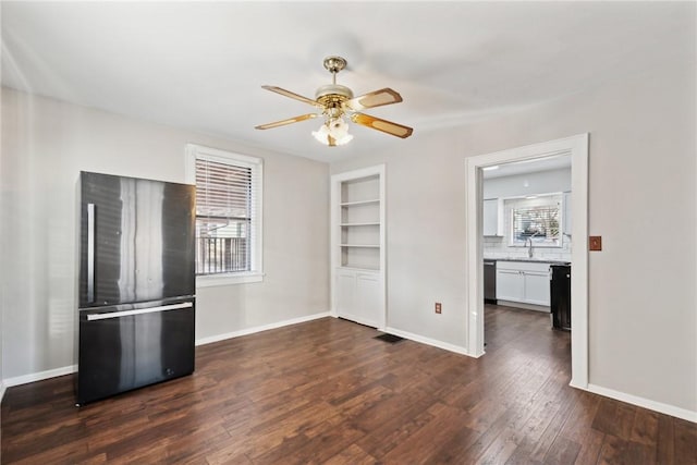 interior space featuring a wealth of natural light, ceiling fan, and dark wood-type flooring