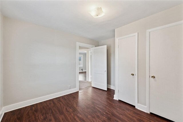 unfurnished bedroom featuring dark wood-type flooring