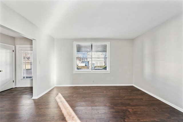 empty room featuring a wealth of natural light and dark hardwood / wood-style floors