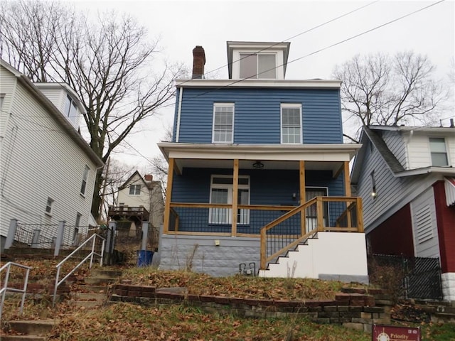 rear view of property featuring covered porch